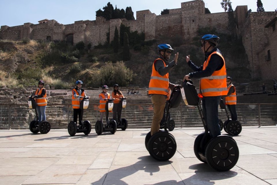 group of tourists on segways on tour in malaga in front of roman theatre